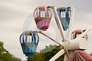 Children`s ferris wheel with booths on the background of sky