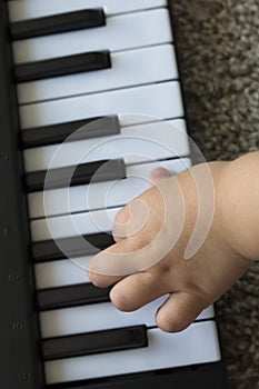 Children`s fingers on the keys of a piano playing