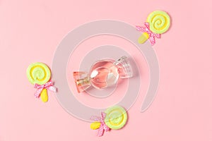 Children`s flat lay. Candy perfume and toy yellow lollipops. Children`s cosmetics, perfumes for little girls