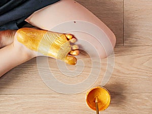 Children`s foot golden color.