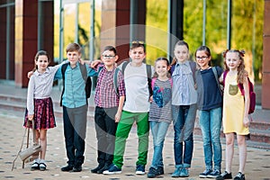 Children`s friendship. Schoolmate students stand in an embrace on the schoolyard. photo