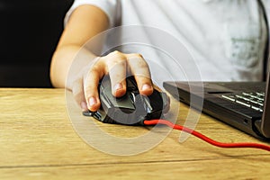 Children`s hand is on a computer mouse.