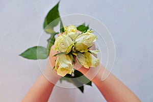 Children`s hand hold five white roses on an Ultimate Gray background.