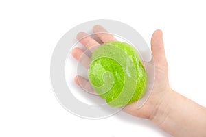 Children`s hand holding a green slime toy. View from above.