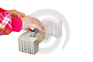 Children's hands build a toy house, close-up, isolated on a white background