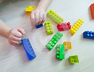 Children`s hands with colorful plastic bricks