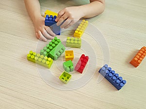 Children`s hands with colorful plastic bricks kindergarten