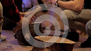 Children`s hands compete in hammering nails into a stump, close-up