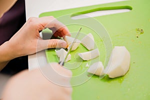 Children`s hands cut apples into pieces