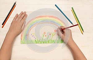 Children`s hands draw a rainbow, flowers, the second stage, a happy childhood, quarantined child, pencils, family, art