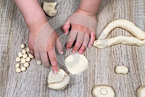 Children`s hands fly figures of salt dough, clay, plasticine on a wooden background. Children`s creativity. Manual