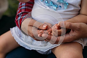 Children`s hands in the hands of an adult.children`s hands in adult hands.adult arms hug childrens. mother holds baby`s hands i