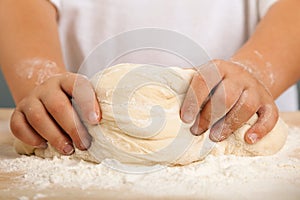 Children`s hands and the hands of his mother and knead dough tog