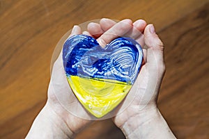 Children`s hands hold a blue-yellow heart of Ukraine, protect ukraine