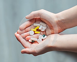 children's hands hold a handful of medicine pills. health day. doctors and medicine.