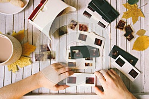 Children's hands hold a retro diascope for viewing negatives. Top view