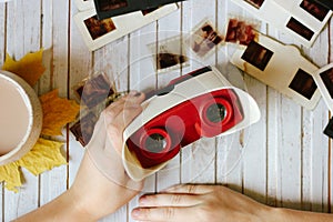 Children's hands hold a retro diascope for viewing negatives. Top view