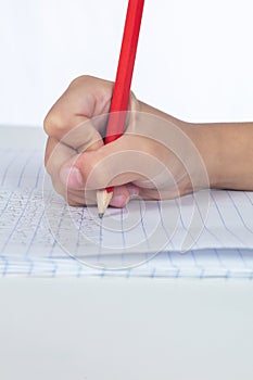 Children`s hands holding pencil and doing homework