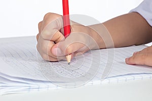 Children`s hands holding pencil and doing homework