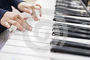 Children`s hands on the keys of the piano. Piano lessons for kids