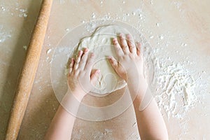 Children`s hands make dough