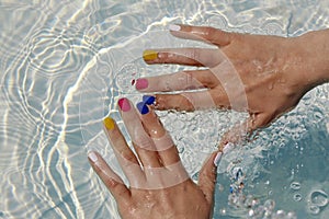 Children`s hands with multi-colored manicure