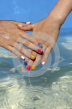 Children`s hands with multi-colored manicure