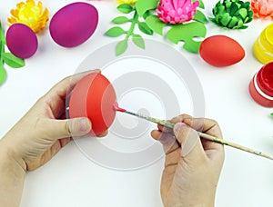 Children`s hands paint Easter eggs. The child is drawing. Easter.