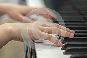 Children`s hands are playing the piano. Child`s hand on piano keys.