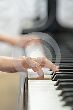 children's hands are playing the piano. Child's hand on piano keys