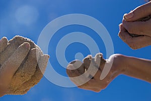 Children`s hands playing in the sand with room to put letters