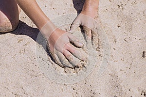 Children`s hands playing in the sand with room to put letters