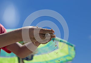 Children`s hands playing in the sand with room to put letters