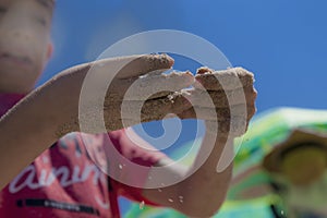 Children`s hands playing in the sand with room to put letters