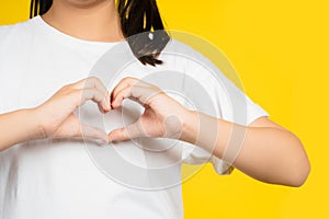 Childre`s hands in the shape of heart, on a yellow isolated background photo