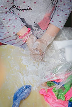 Children`s hands are soiled in flour
