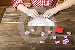 Children`s hands write a love message on Valentine`s Day. Stamps with hearts and love on the letter closeup and copy space