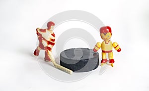 Children`s Hockey. Two red toy hockey players stand next to the puck