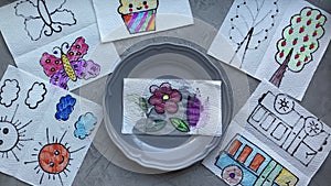 Children`s home performance, drawings become multi-colored, with the help of water on a plate.