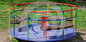 Children`s iron carousel. Children`s playground. Swing, carousel and slide photo
