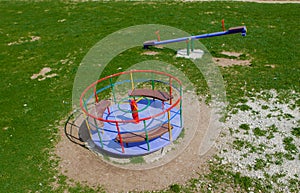 Children`s iron carousel. Children`s playground. Swing, carousel and slide photo