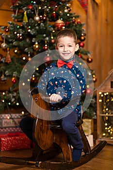 Children`s joyful memories of Christmas holidays. Santa gave a little boy a swing horse