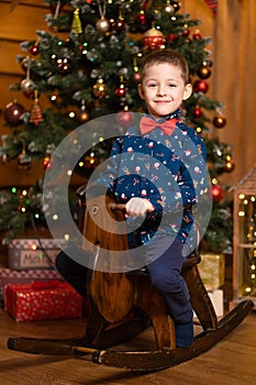 Children`s joyful memories of Christmas holidays. Santa gave a little boy a swing horse