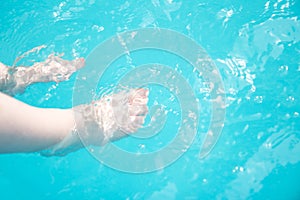 Children`s legs in the pool. Summer vacation