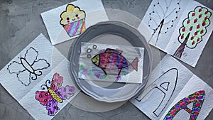 Children`s magic experience, children`s hands put the drawing in a plate