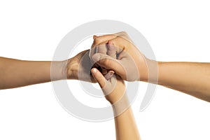 Children`s, mother`s and father`s hands holding together on a white background in the studio