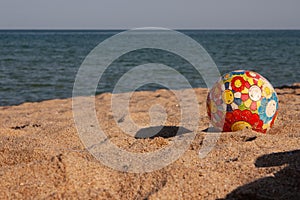 Children`s multi-colored ball on the beach