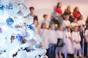 Children`s New Year`s Choir. Christmas tree and children`s choir. Christmas and New Year concept. Blurry photo