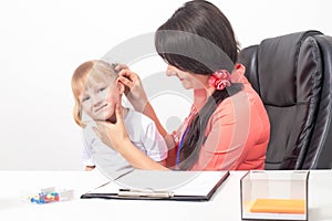 Children`s otolaryngologist examines the ear of a little girl 3-4 years who has pain and inflammation of the eardrum. Sulfur ear