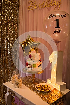 Children`s photo zone with sweets and a balloons. Decorations for a One year old Girlâ€™s Birthday party.